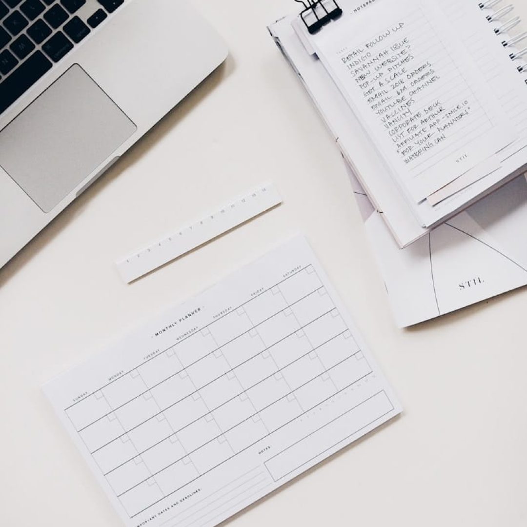 silver laptop computer near notebook